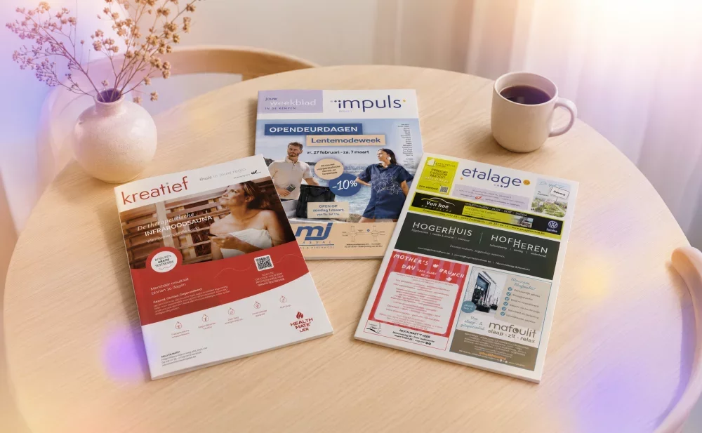Magazines impuls, etalage en kreatief liggen op een licht houten tafel met een kopje koffie ernaast