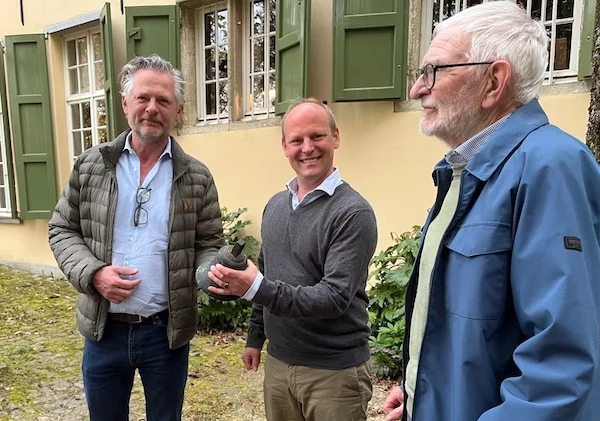 Jef Huet en Staf Peerlinck overhandigen het klokje van het Seminarie aan Jasper Bijnen.