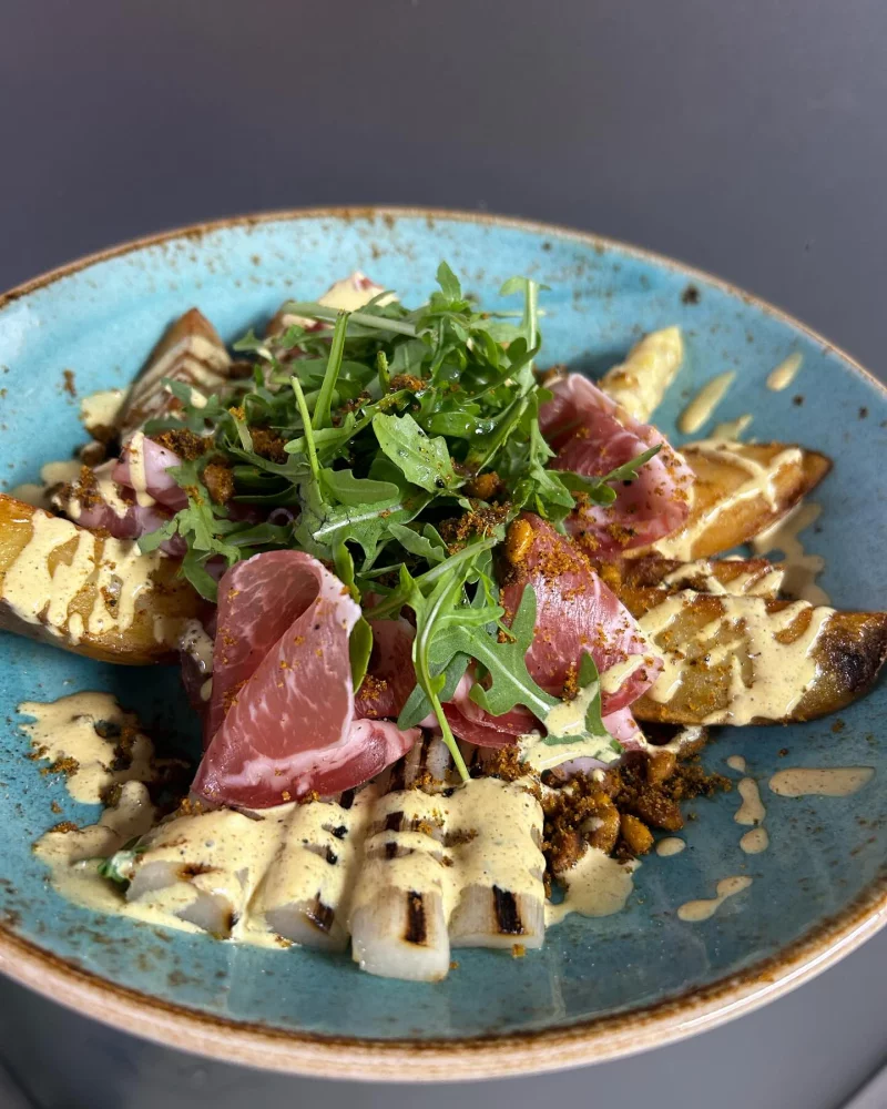 Gerecht met asperges, rauwe ham en rucola van Trattoria Kapellen
